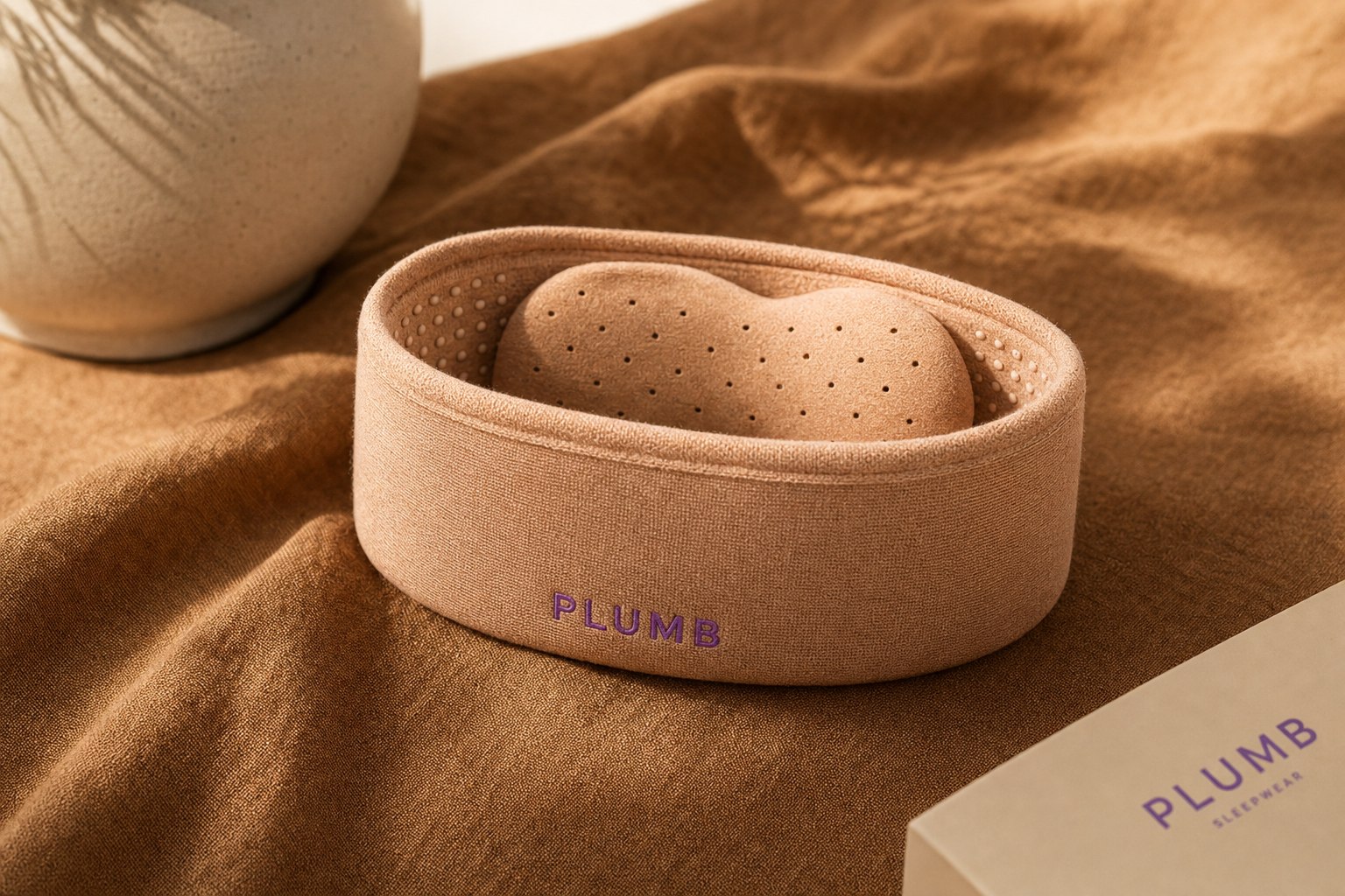 Color rendering of the Plumb band in Dune colorway: warm terracotta-tinted oatmeal bamboo-derived viscose knit with purple PLUMB embroidery. Color study, not a final product photograph.